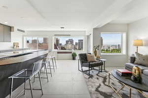 Living room with a wealth of natural light and light tile flooring