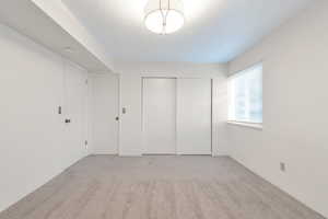 Unfurnished bedroom with light colored carpet and a closet