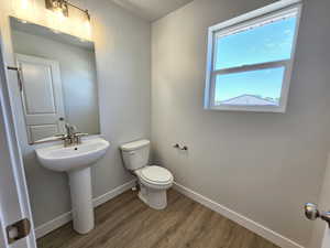 Bathroom with hardwood / wood-style flooring and toilet