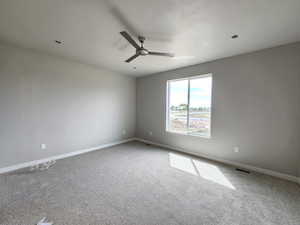 Unfurnished room featuring carpet, ceiling fan, and a textured ceiling