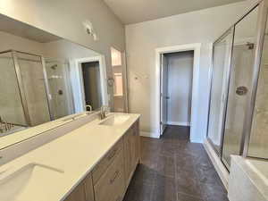 Bathroom featuring a shower with door, double vanity, and tile flooring