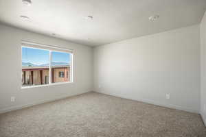 Carpeted empty room with a textured ceiling