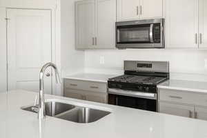 Kitchen with sink and appliances with stainless steel finishes