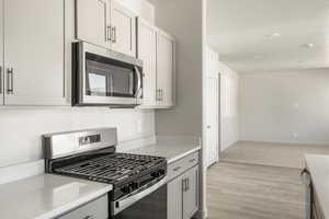 Kitchen with appliances with stainless steel finishes and light colored carpet