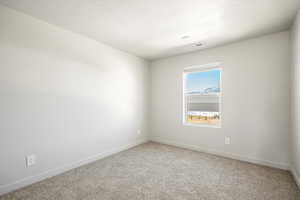 Unfurnished room with a textured ceiling and carpet flooring