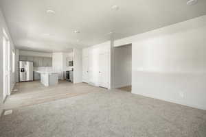 Unfurnished living room with sink and light wood-type flooring