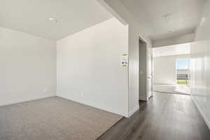 Corridor with dark hardwood / wood-style flooring and a textured ceiling