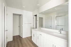 Bathroom featuring dual vanity and wood-type flooring