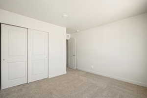 Unfurnished bedroom with light colored carpet and a closet