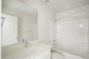 Full bathroom featuring vanity, shower / bath combination, and toilet