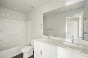 Full bathroom featuring shower / washtub combination, wood-type flooring, toilet, and double sink vanity