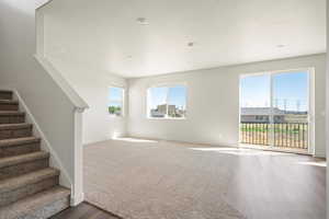 Unfurnished living room with plenty of natural light and dark hardwood / wood-style floors