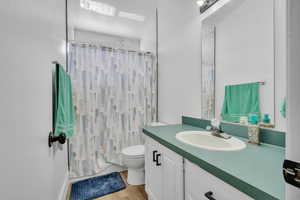 Bathroom featuring wood-type flooring, toilet, and vanity