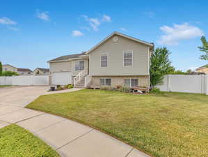 View of front of property with a garage and a front lawn