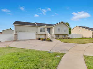 Bi-level home featuring a front lawn and a garage