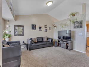 Living room with lofted ceiling and carpet flooring