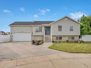 View of front of property featuring a garage and a front lawn