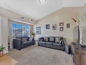 Living room featuring carpet flooring and vaulted ceiling