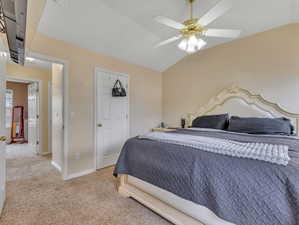 Bedroom featuring ceiling fan, light colored carpet, and lofted ceiling