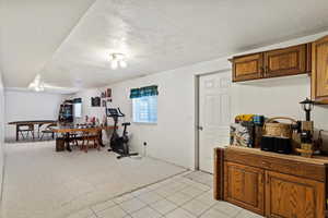 Kitchen featuring light colored carpet and a textured ceiling