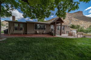 Front of house featuring a lawn and a patio area.