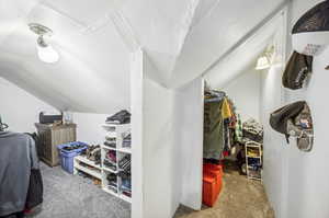 Walk in closet featuring carpet and vaulted ceiling