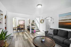 Living room with built in features and light hardwood / wood-style flooring;  Arched doorways