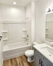 Full bathroom featuring vanity,  shower combination, hardwood / wood-style flooring, and toilet