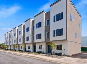 View of building exterior featuring central AC unit