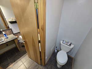 Bathroom featuring tile floors, vanity, and toilet