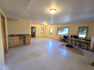 Living room featuring sink, a textured ceiling, and rail lighting