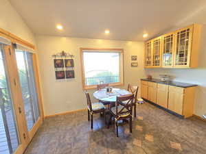 Tiled dining room with vaulted ceiling