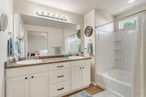 Primary Bathroom with double sink vanity and shower / tub combo