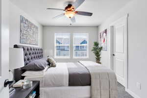 Carpeted bedroom featuring ceiling fan