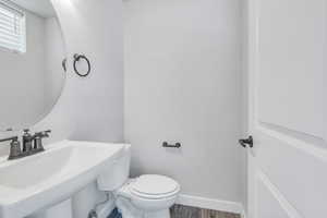 Bathroom with sink, wood-type flooring, and toilet