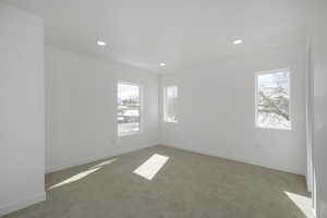 Empty room featuring a healthy amount of sunlight and carpet floors