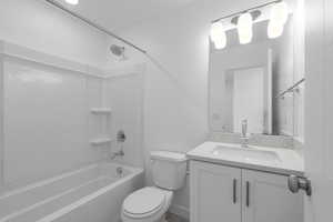 Full bathroom with large vanity, toilet, and shower / washtub combination