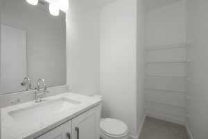 Bathroom with tile flooring, oversized vanity, and toilet