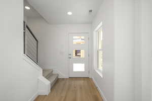 Foyer entrance featuring plenty of natural light and light wood-type flooring