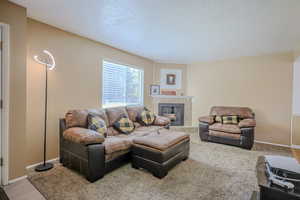 Carpeted living room with a tile fireplace