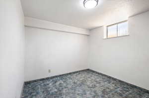 Basement with a textured ceiling and carpet floors