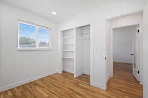 Unfurnished bedroom featuring a closet and light hardwood / wood-style flooring