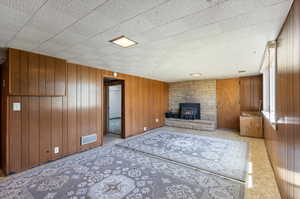 Living room with wooden walls and a stone fireplace