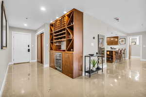 Entryway with built-in wine rack and sleek wine fridge.