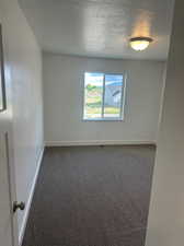 Carpeted spare room with a textured ceiling