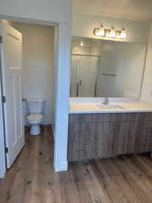 Bathroom featuring vanity, toilet, and hardwood / wood-style floors