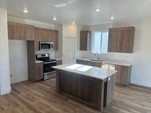 Kitchen featuring a kitchen island, sink, stainless steel appliances, and hardwood / wood-style floors