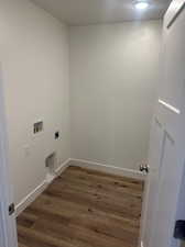 Clothes washing area with hookup for a washing machine, wood-type flooring, and hookup for an electric dryer