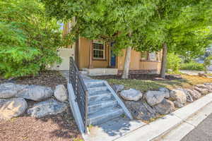 View of property hidden behind natural elements featuring covered porch