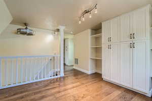 Interior space with track lighting, light hardwood / wood-style flooring, and a textured ceiling